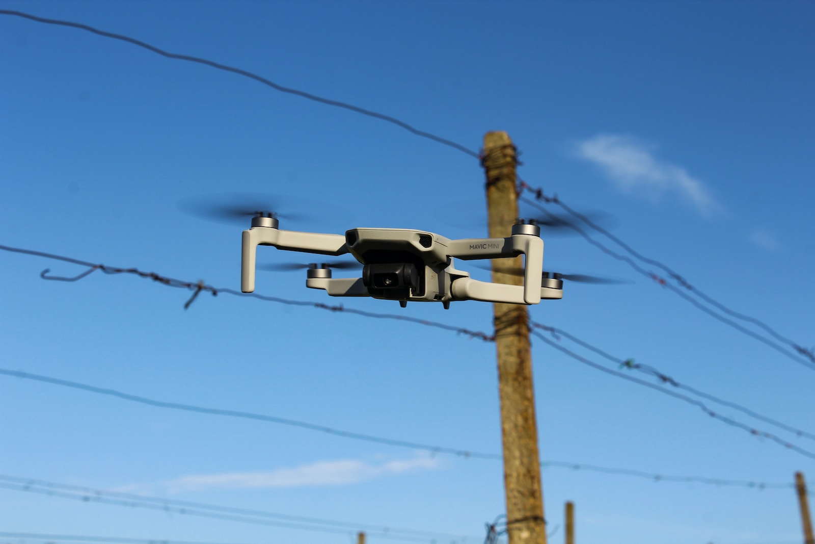 a camera attached to a pole with power lines in the background